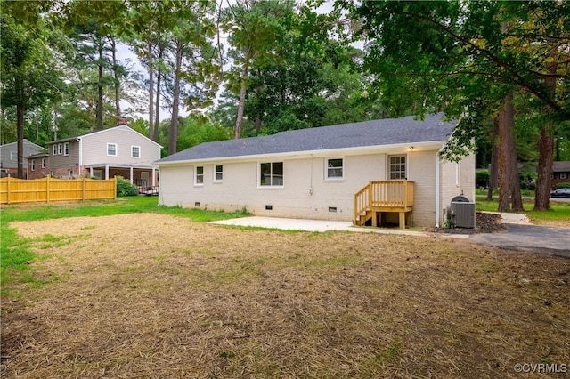 rear view of property featuring brick siding, fence, central air condition unit, a patio area, and crawl space