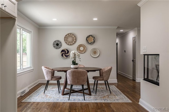 dining space featuring dark wood-type flooring, visible vents, baseboards, and ornamental molding