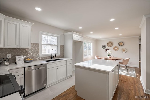 kitchen featuring tasteful backsplash, a sink, a center island, dishwasher, and range