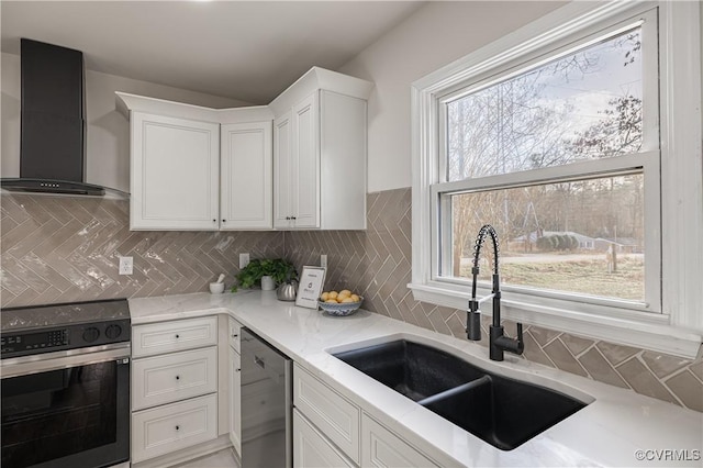 kitchen featuring range with electric cooktop, a sink, stainless steel dishwasher, wall chimney exhaust hood, and white cabinets