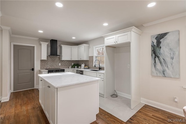 kitchen featuring a kitchen island, a sink, stainless steel range with electric cooktop, white cabinets, and wall chimney exhaust hood