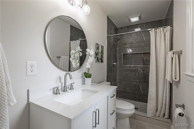 full bathroom with vanity, tile patterned floors, toilet, and tiled shower