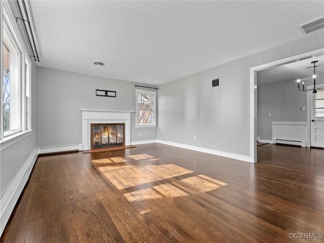 unfurnished living room with visible vents, wood finished floors, a glass covered fireplace, and a baseboard radiator