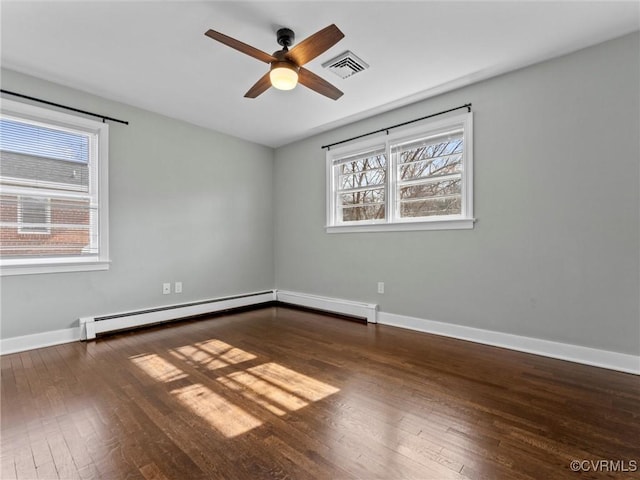 unfurnished room with hardwood / wood-style floors, visible vents, baseboards, and a baseboard heating unit