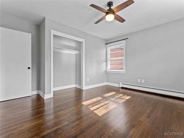 unfurnished bedroom with ceiling fan, baseboards, baseboard heating, wood finished floors, and a closet