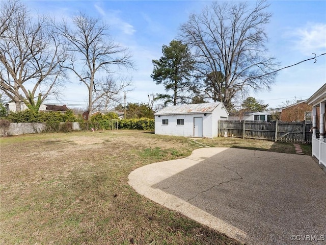 view of yard with an outbuilding, a patio area, and a fenced backyard