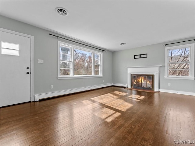 unfurnished living room featuring a glass covered fireplace, baseboards, wood-type flooring, and a baseboard radiator