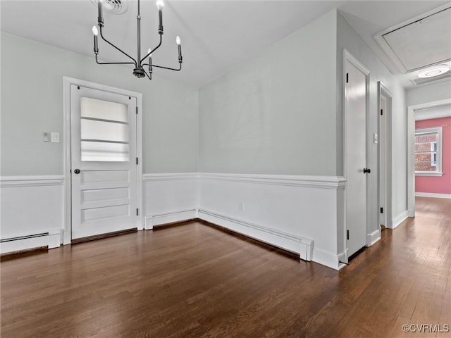 unfurnished dining area with a notable chandelier, wood finished floors, a baseboard radiator, baseboards, and attic access