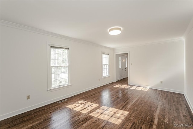 empty room featuring crown molding, dark wood-style floors, visible vents, and baseboards