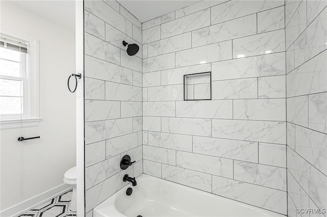 bathroom featuring toilet, washtub / shower combination, and baseboards