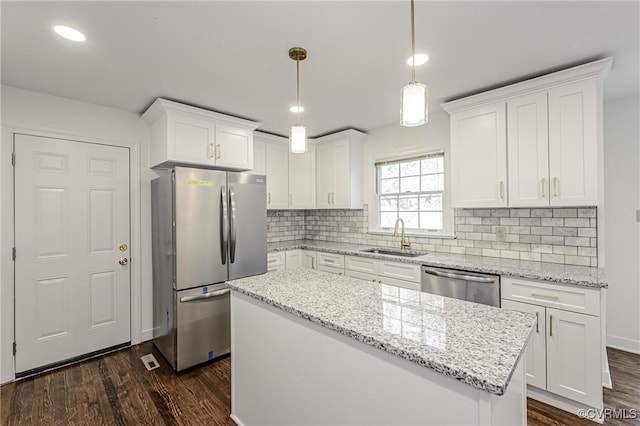 kitchen with dark wood-style floors, white cabinets, stainless steel appliances, and a sink