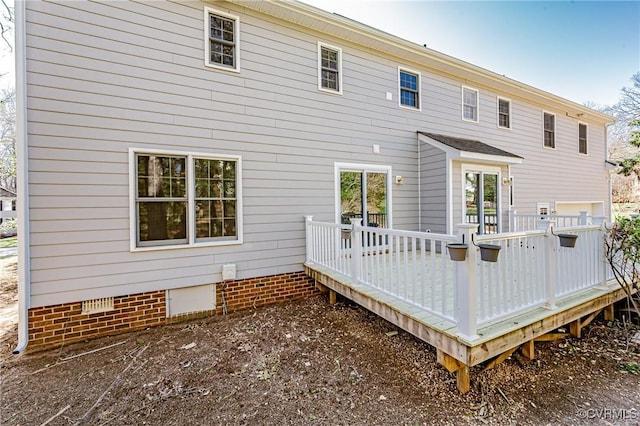 rear view of house featuring a wooden deck and crawl space