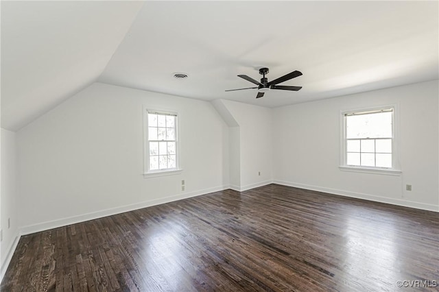 bonus room with visible vents, baseboards, vaulted ceiling, dark wood-style floors, and a ceiling fan