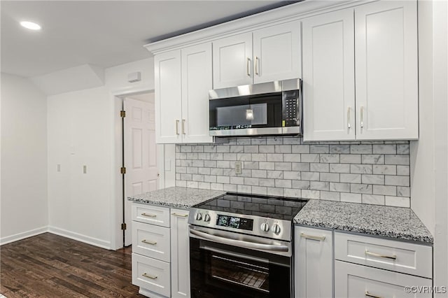 kitchen with stainless steel appliances, light stone countertops, backsplash, and dark wood-style floors