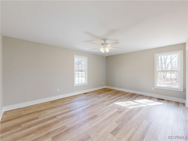 empty room featuring visible vents, baseboards, light wood-style floors, and a ceiling fan