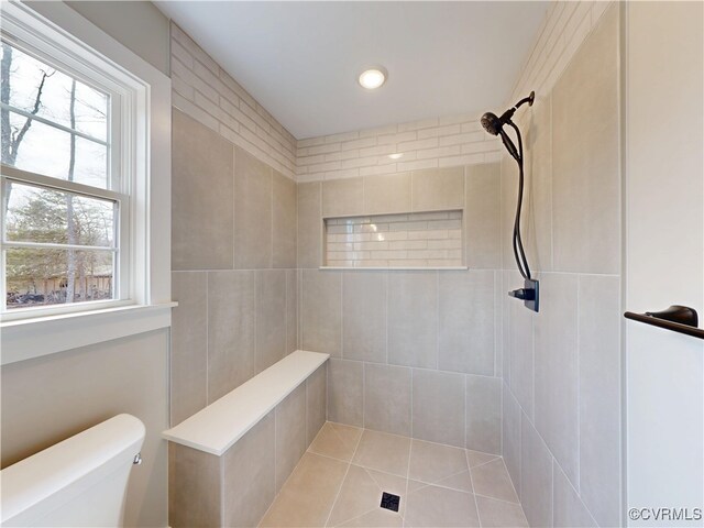 bathroom with toilet and a tile shower