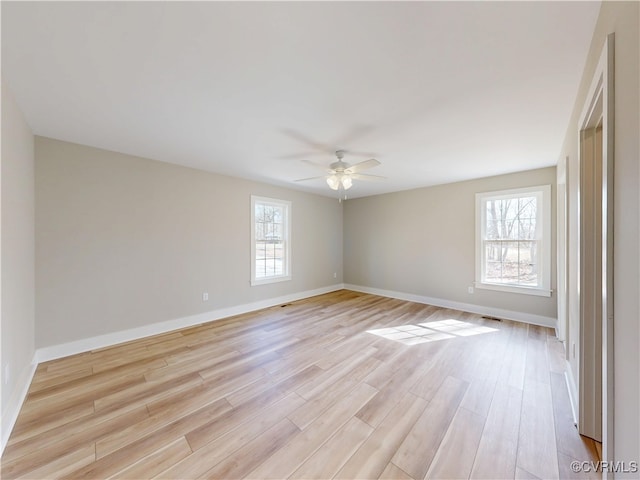 unfurnished room with a wealth of natural light, light wood-style flooring, and baseboards