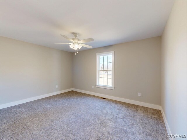 spare room featuring visible vents, a ceiling fan, baseboards, and carpet floors