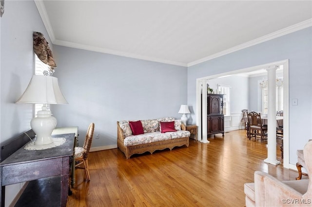 living room with crown molding, wood finished floors, and baseboards