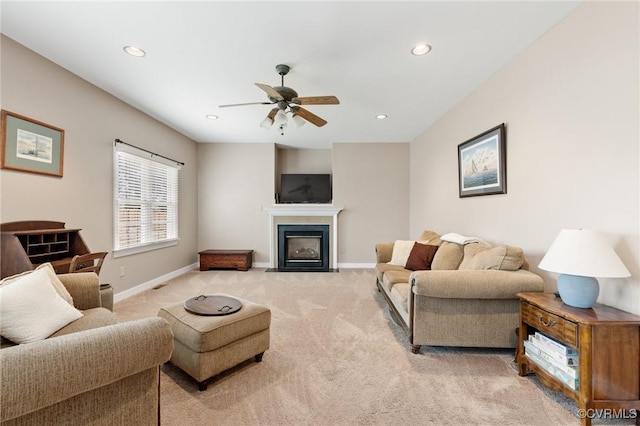 living room featuring recessed lighting, baseboards, light carpet, and a fireplace with flush hearth