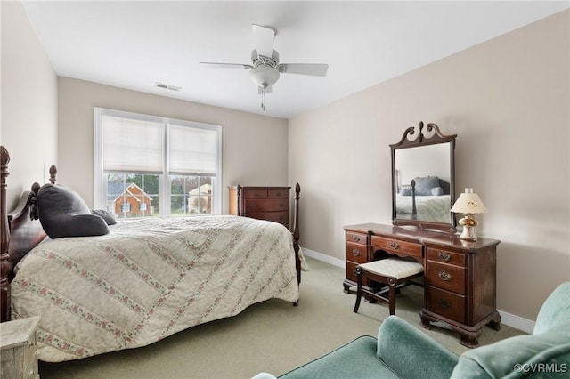 carpeted bedroom with visible vents, baseboards, and a ceiling fan