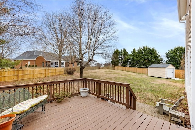 deck with a storage shed, an outbuilding, a yard, and a fenced backyard