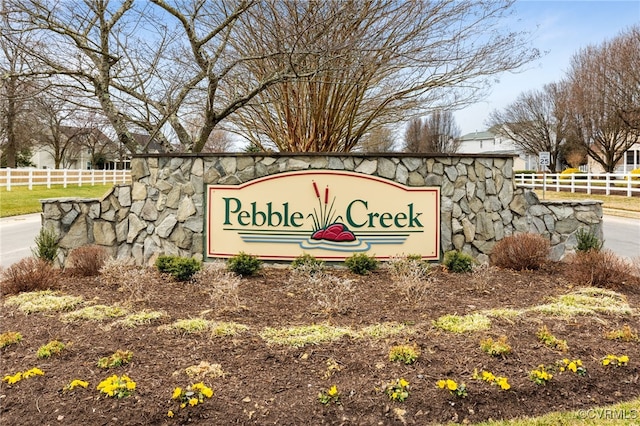 community / neighborhood sign with fence