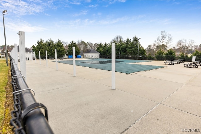 pool with a patio area and fence