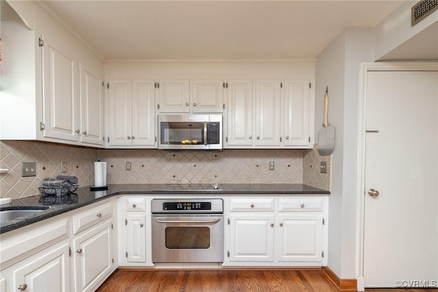 kitchen featuring visible vents, appliances with stainless steel finishes, wood finished floors, and white cabinetry