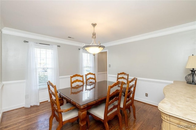 dining space featuring dark wood-type flooring, baseboards, and ornamental molding