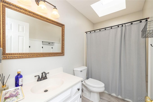 bathroom featuring vanity, a skylight, toilet, and a shower with curtain