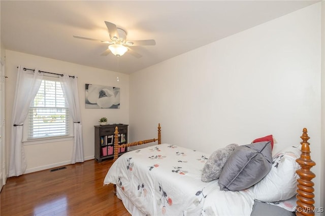 bedroom with visible vents, ceiling fan, baseboards, and wood finished floors