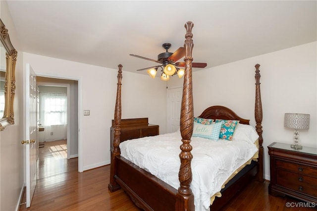 bedroom featuring a ceiling fan, baseboards, and wood finished floors