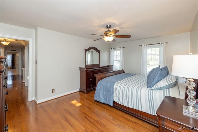 bedroom with baseboards, light wood-style flooring, and a ceiling fan