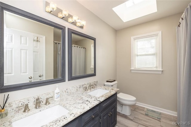 full bathroom with double vanity, toilet, baseboards, and a sink