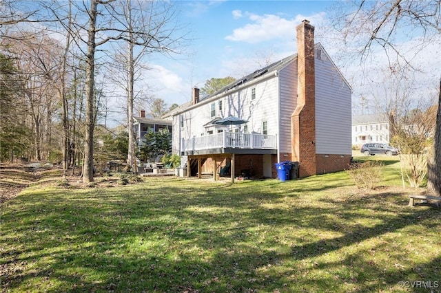 exterior space featuring a deck, a yard, and a chimney