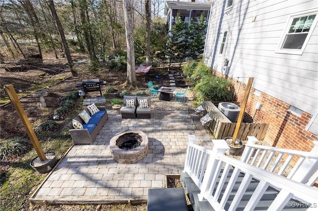 view of patio / terrace with an outdoor living space with a fire pit and central AC