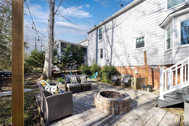 view of patio with an outdoor living space with a fire pit