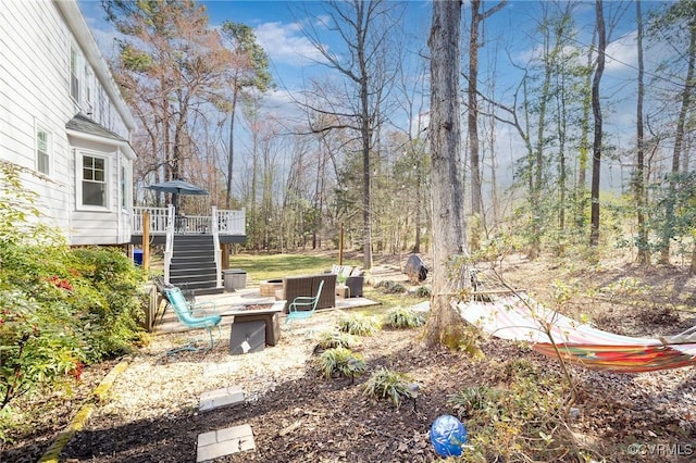 view of yard featuring a wooden deck, stairway, and an outdoor fire pit