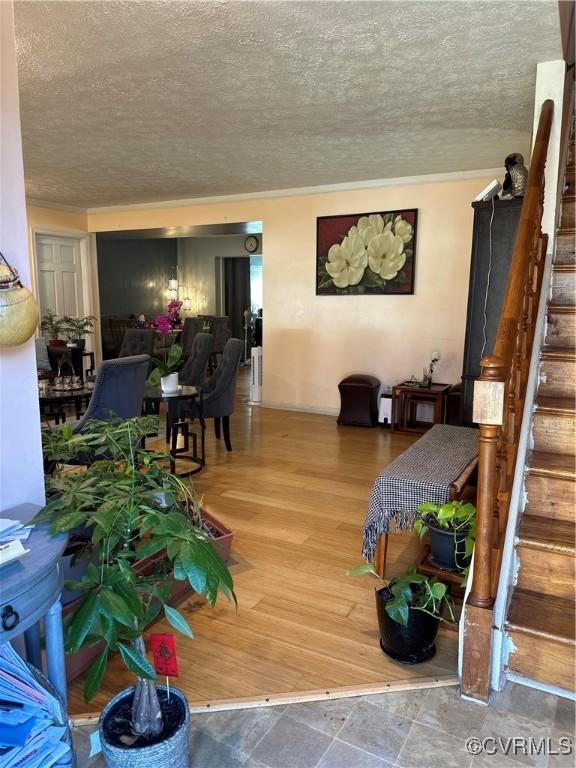 living area featuring stairway, wood finished floors, and a textured ceiling