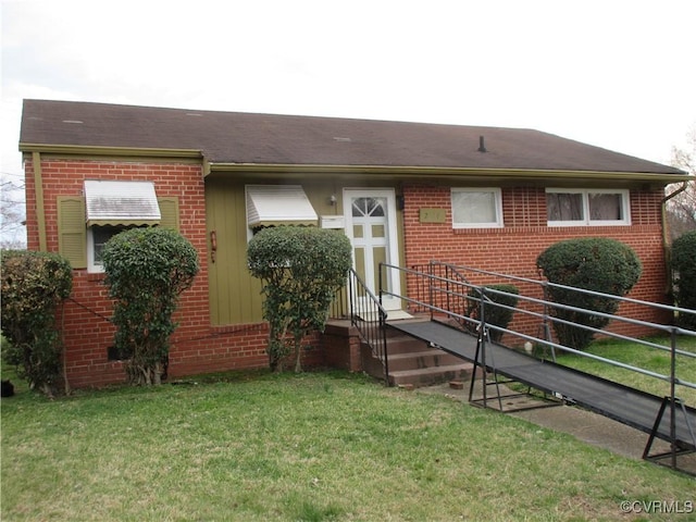 view of front facade featuring brick siding and a front lawn