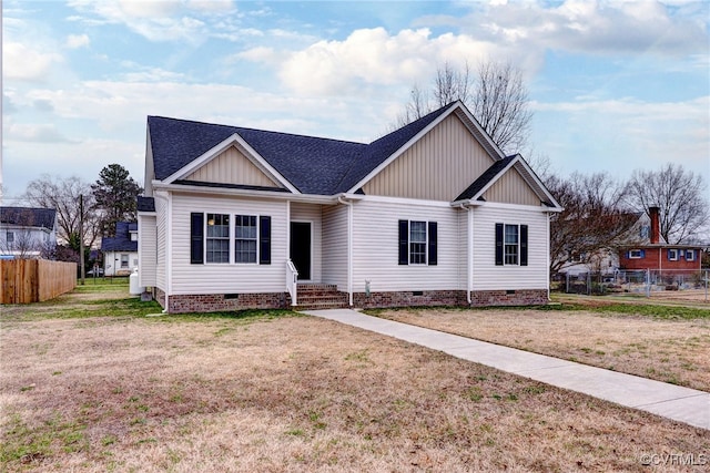 view of front of house featuring crawl space, roof with shingles, a front lawn, and fence