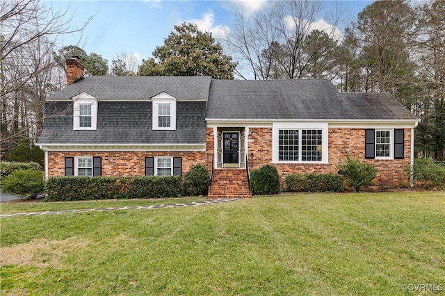 tri-level home with a front lawn, a chimney, brick siding, and a shingled roof