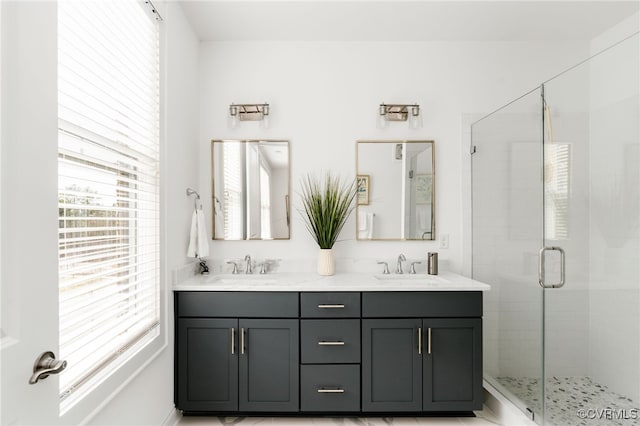 full bathroom with a sink, a stall shower, and double vanity