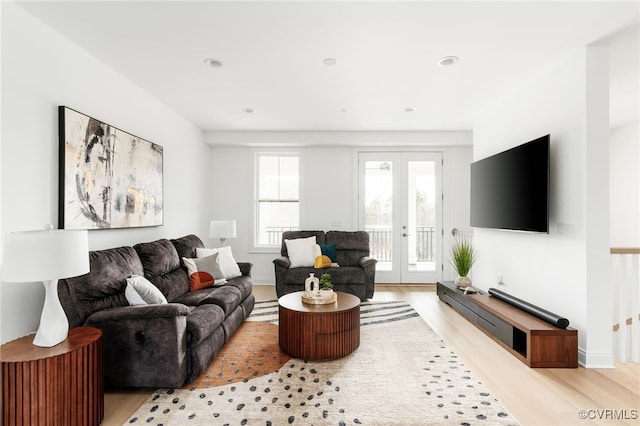 living room featuring recessed lighting, french doors, light wood-type flooring, and baseboards