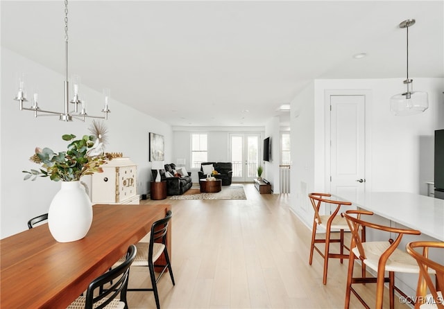 dining space with light wood-style flooring and french doors