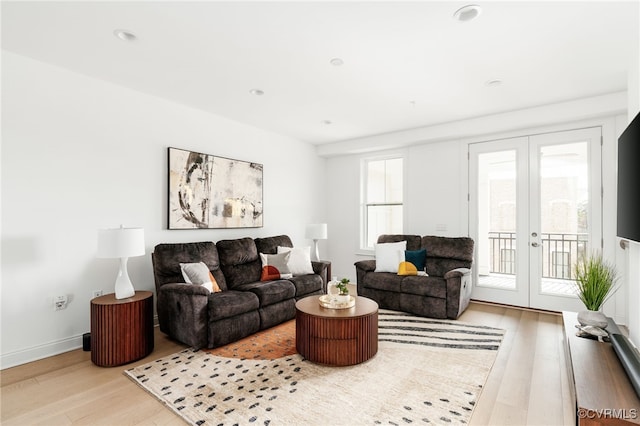 living room featuring french doors, baseboards, and wood finished floors