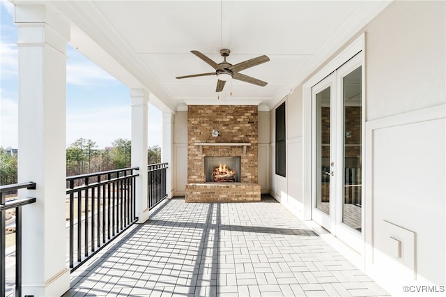 balcony with ceiling fan and an outdoor brick fireplace