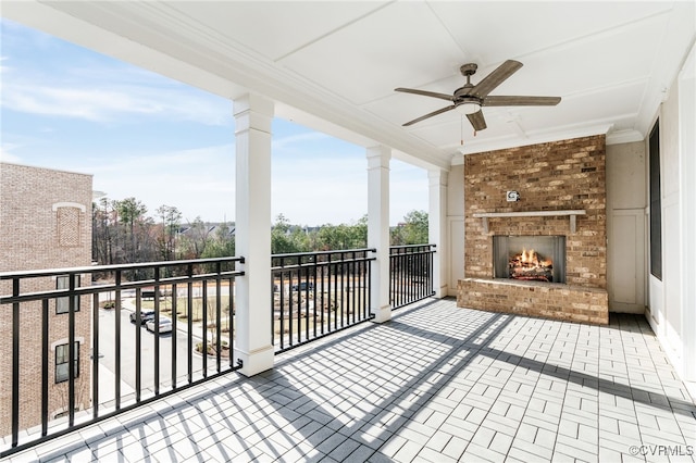 balcony with ceiling fan and an outdoor brick fireplace