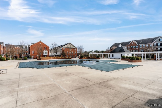 pool with a residential view and a patio